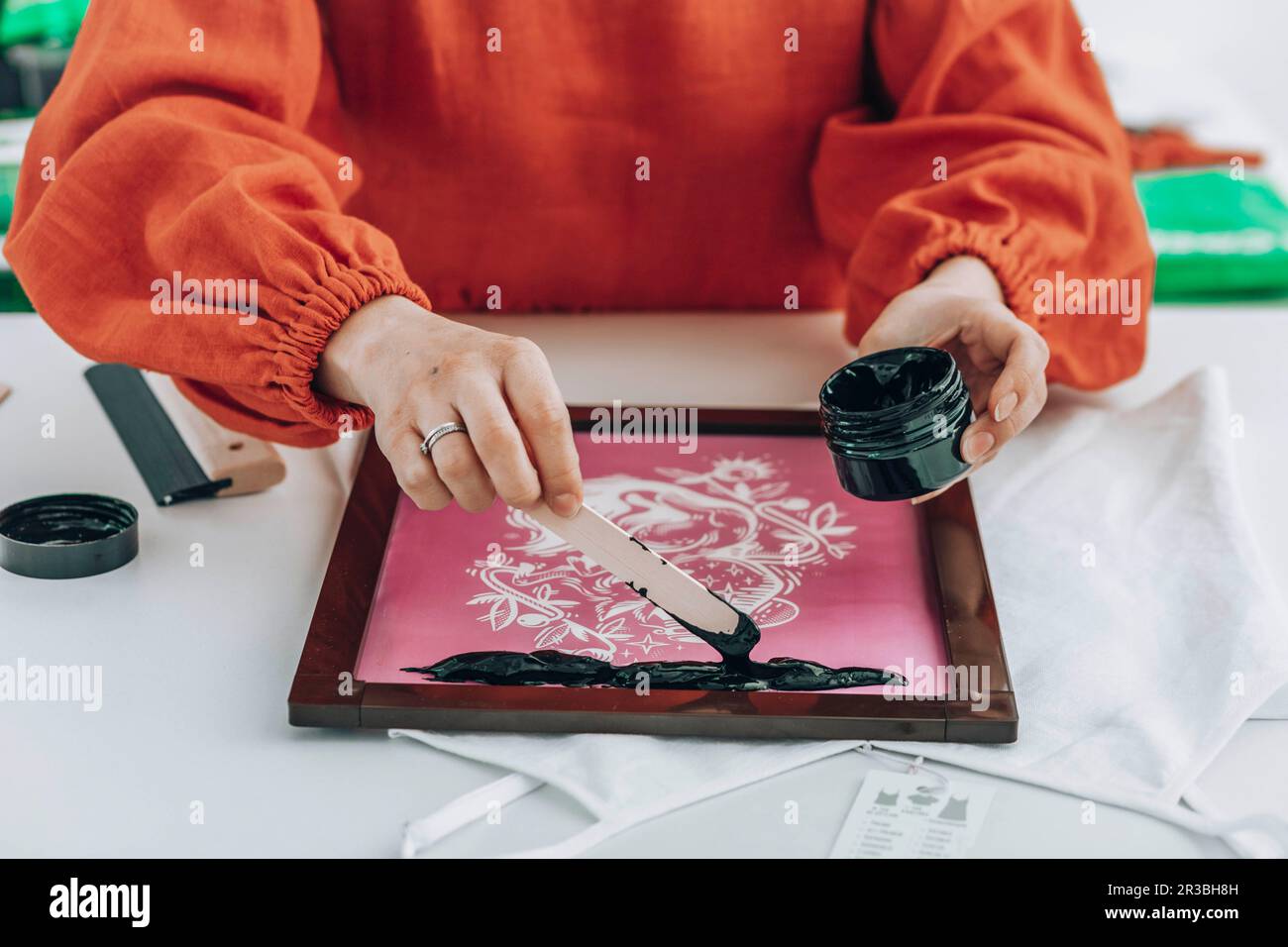 Designer Ink Fashion designer applying black ink on fabric at workshop Stock Photo ...