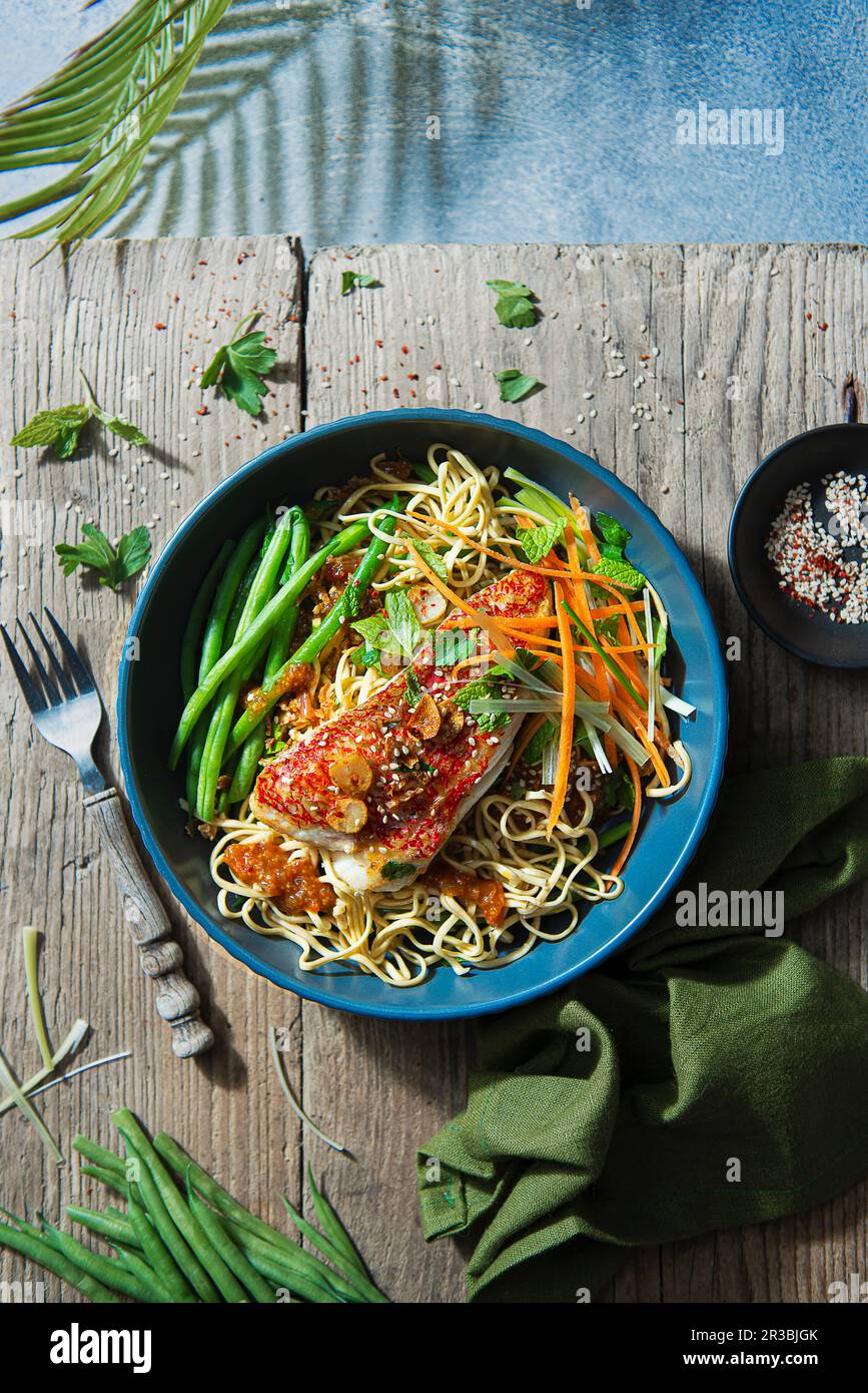 Oriental noodles with chilli jam, beans, herbs and grilled red snapper