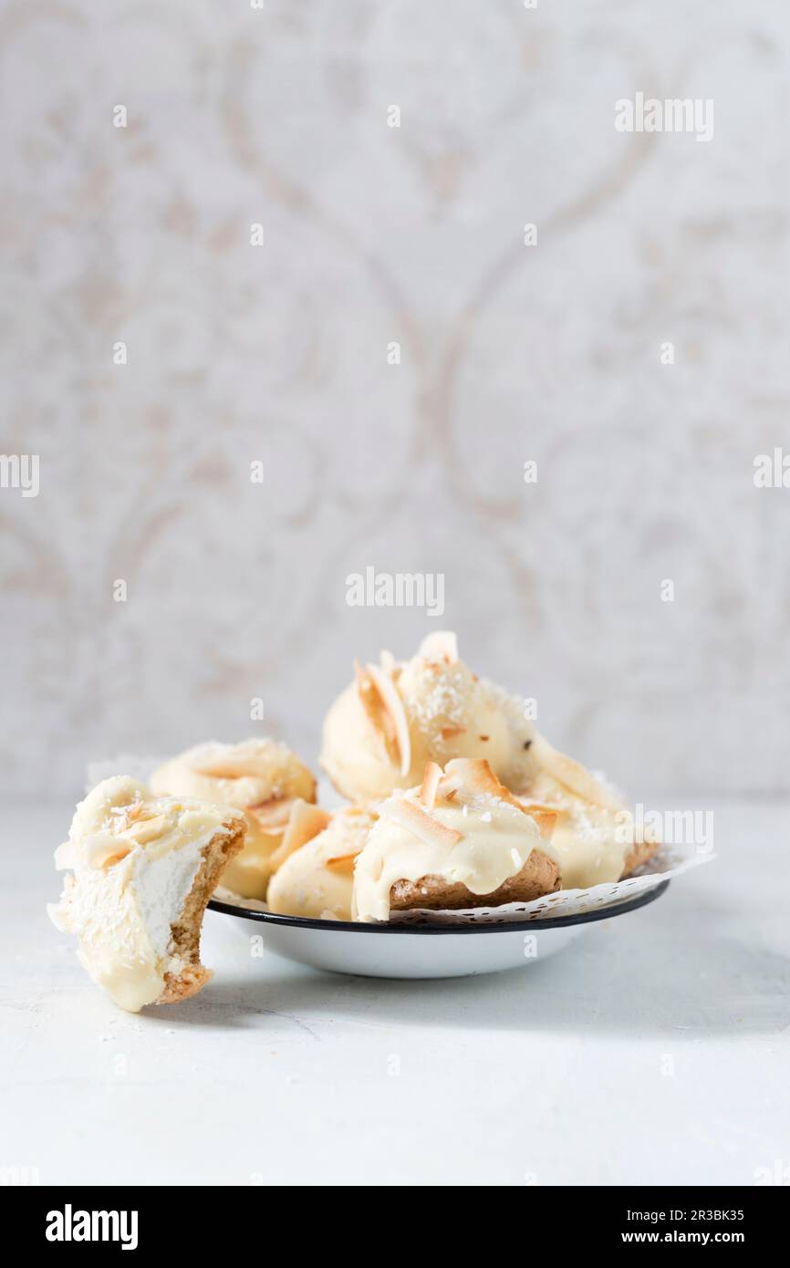 Homemade foam kisses with white chocolate and coconut shavings on a