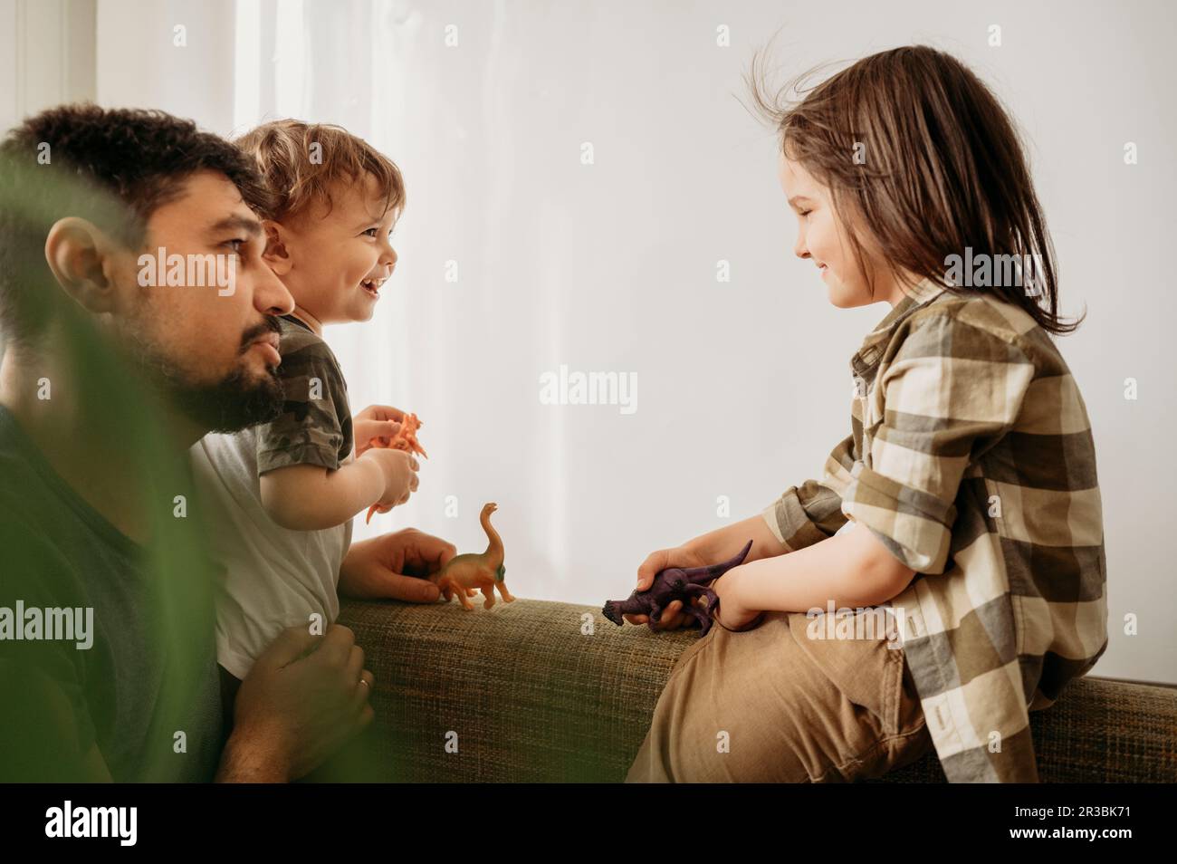 Father spending leisure time with sons playing at home Stock Photo