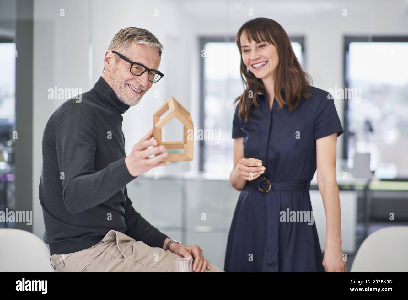 Two smiling architects looking at model house in office Stock Photo