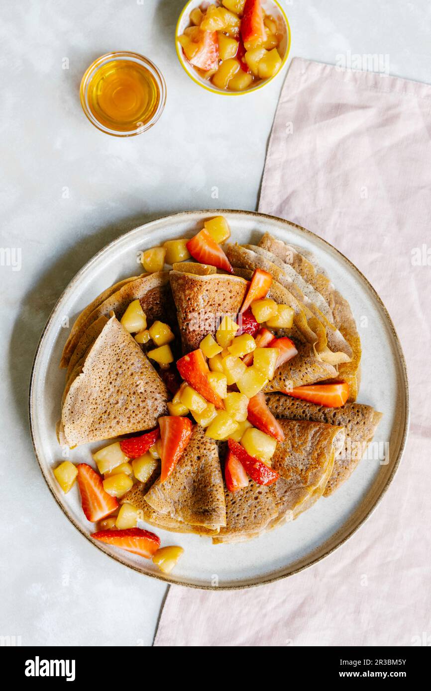 Cinnamon crepes with caramelized apples and strawberries Stock Photo