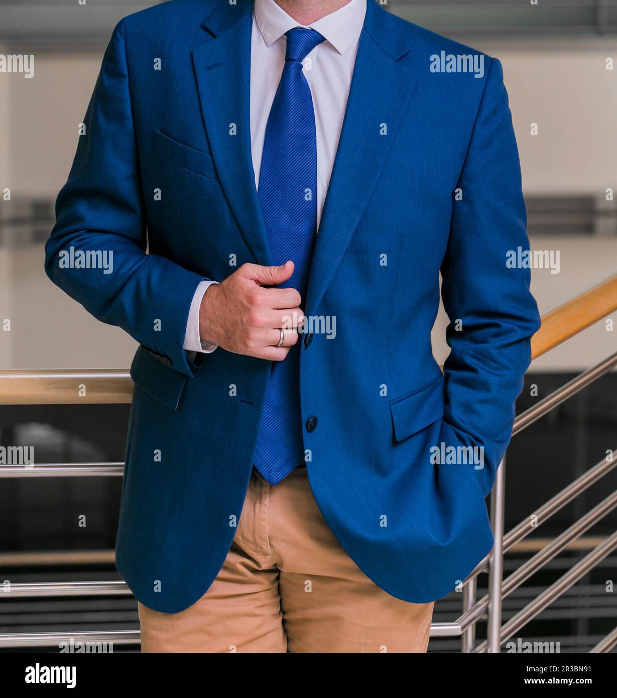Cropped Head Man standing in a smart suit with hand one hand in pocket Stock Photo