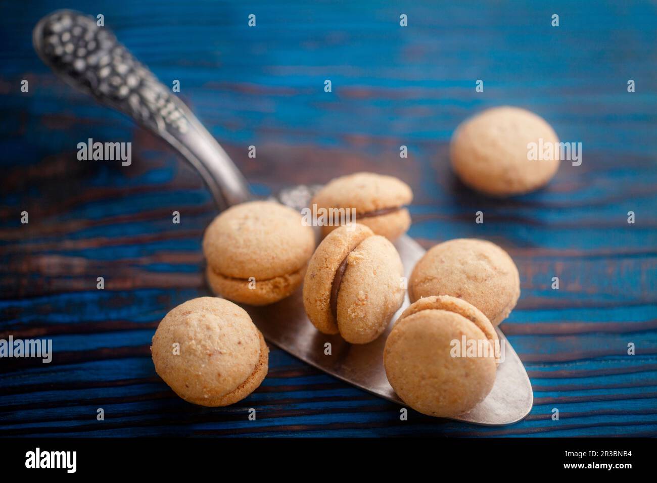Baci di dama (Italian hazelnut biscuits) on a cake slice Stock Photo