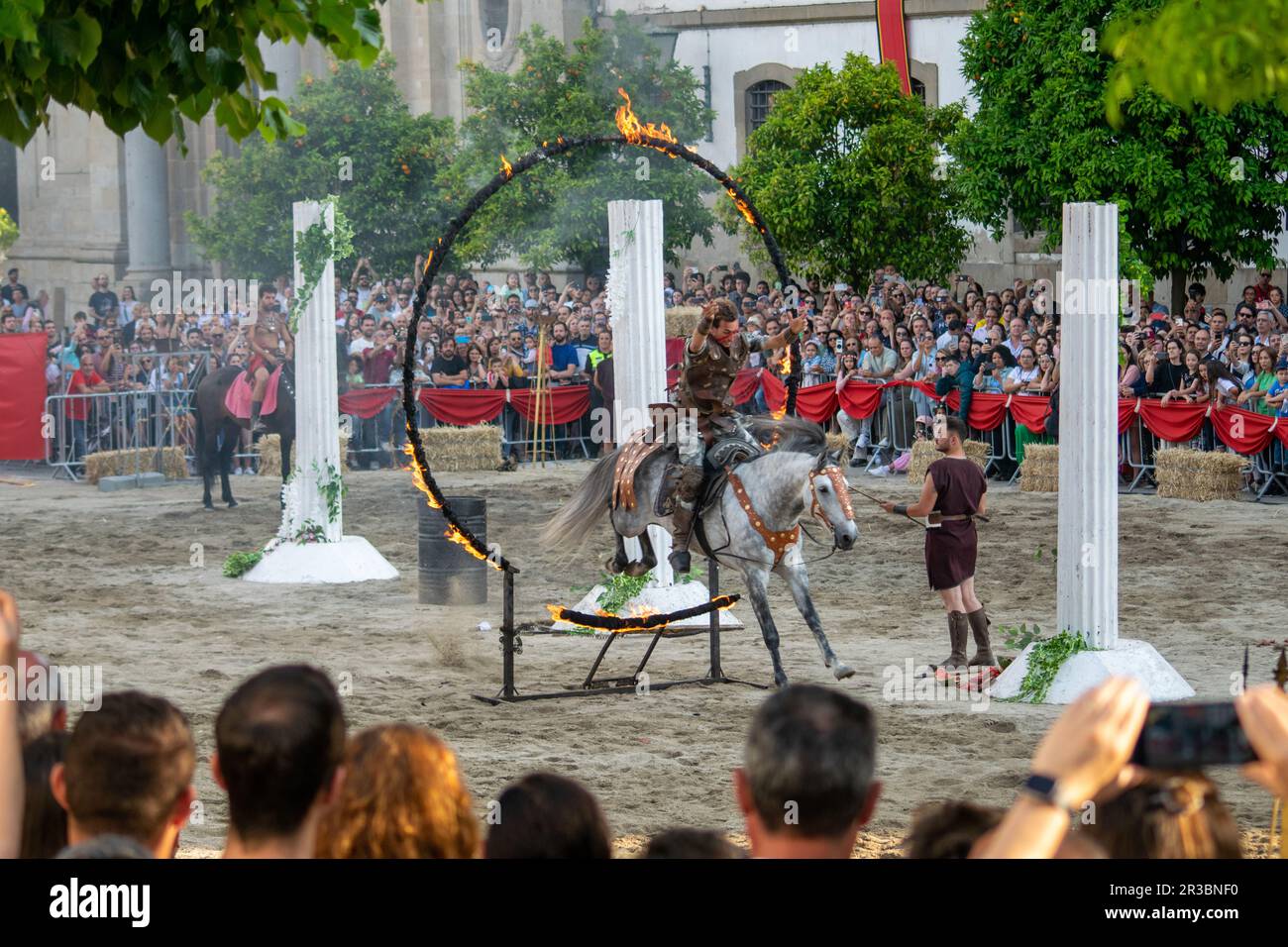 Roman acting, gladiator jumping a ring of fire mounted in his horse with his hands in the air. Outdoor performers. Historical events and representation. Stock Photo