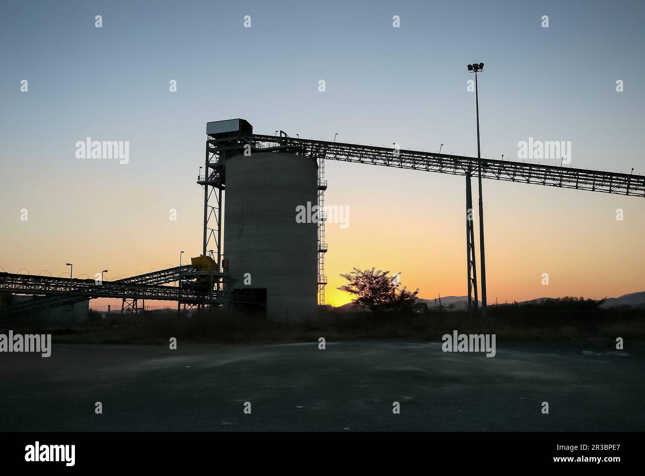 Silhouette of a mining silo and conveyor belts Stock Photo