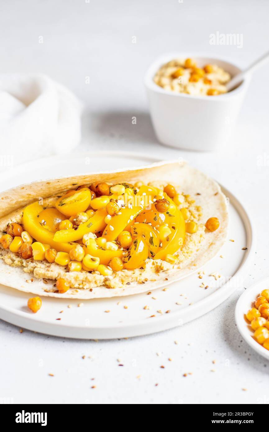 Yellow humus wrap with corn and pepper Stock Photo - Alamy