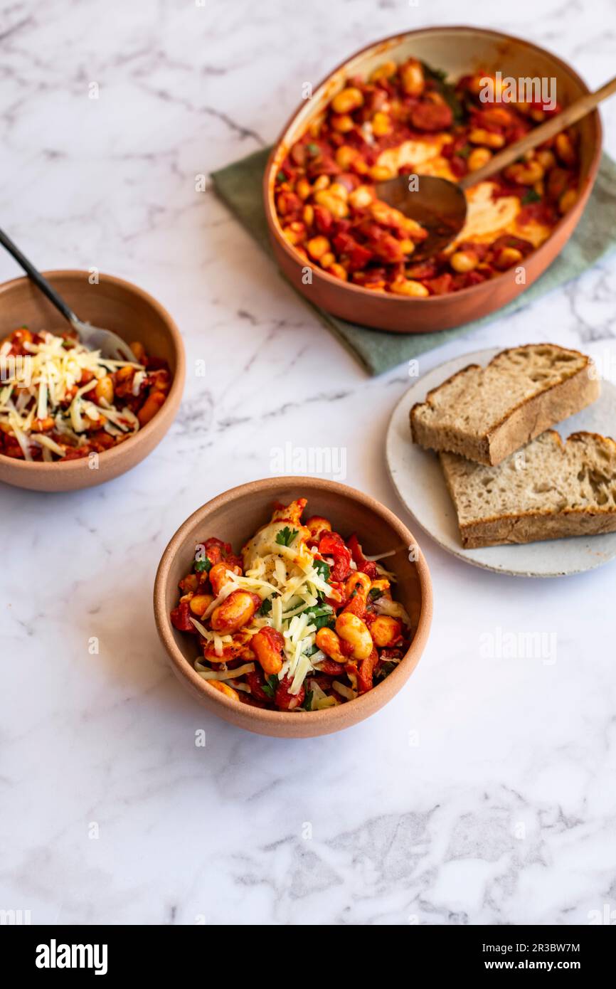 Oven baked beans with baked eggs, grated cheese and sourdough bread