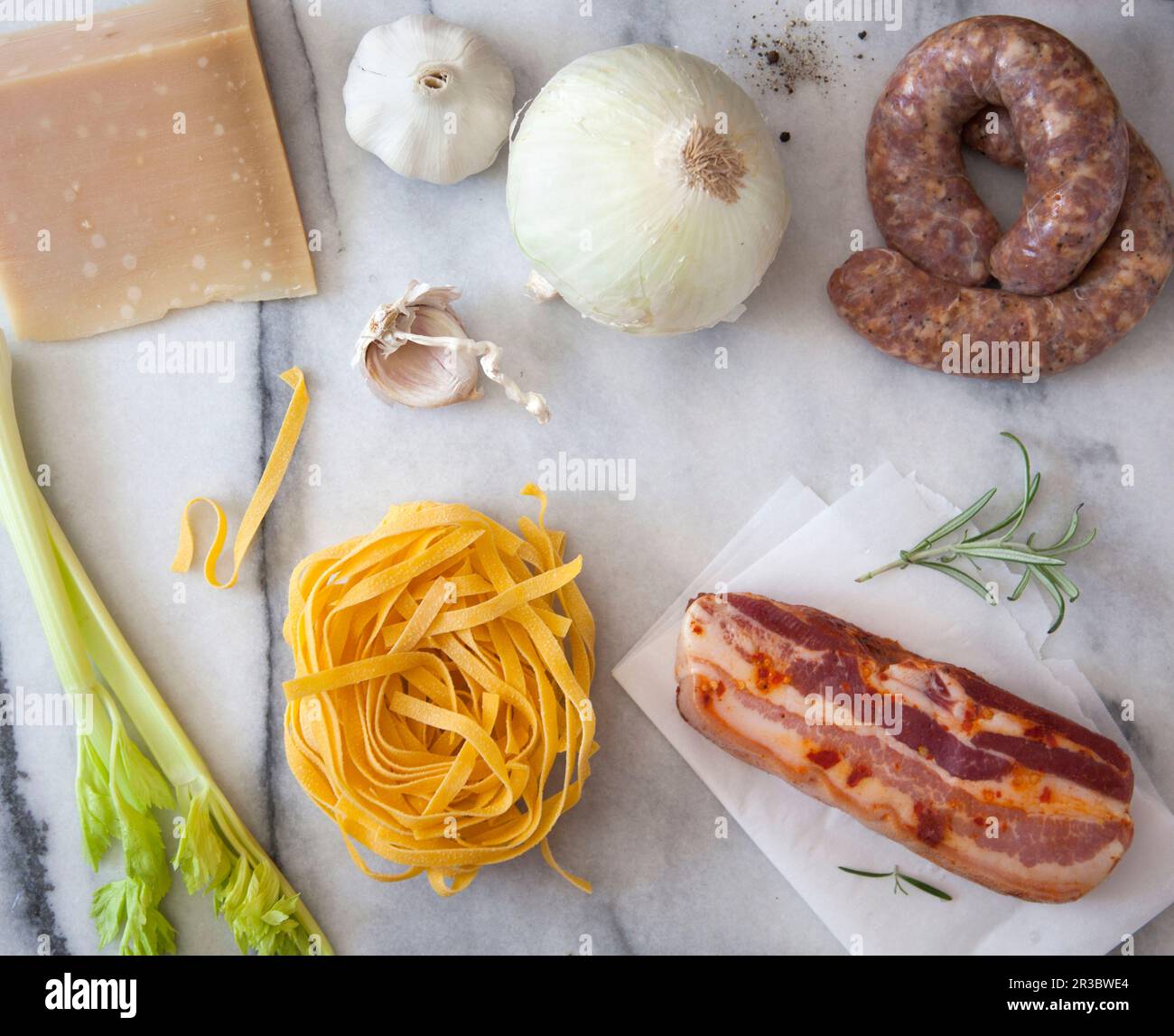 Pasta ingredients parmesan cheese, white onion, sausage, garlic