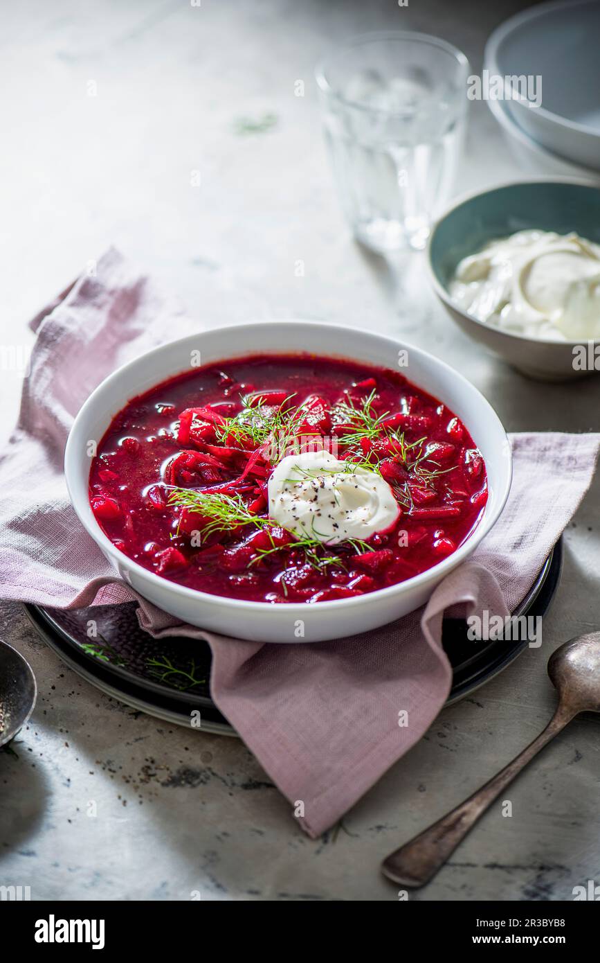 Beetroot borscht with beetroot, cabbbage, potatoes, garnish with dill and sour cream Stock Photo