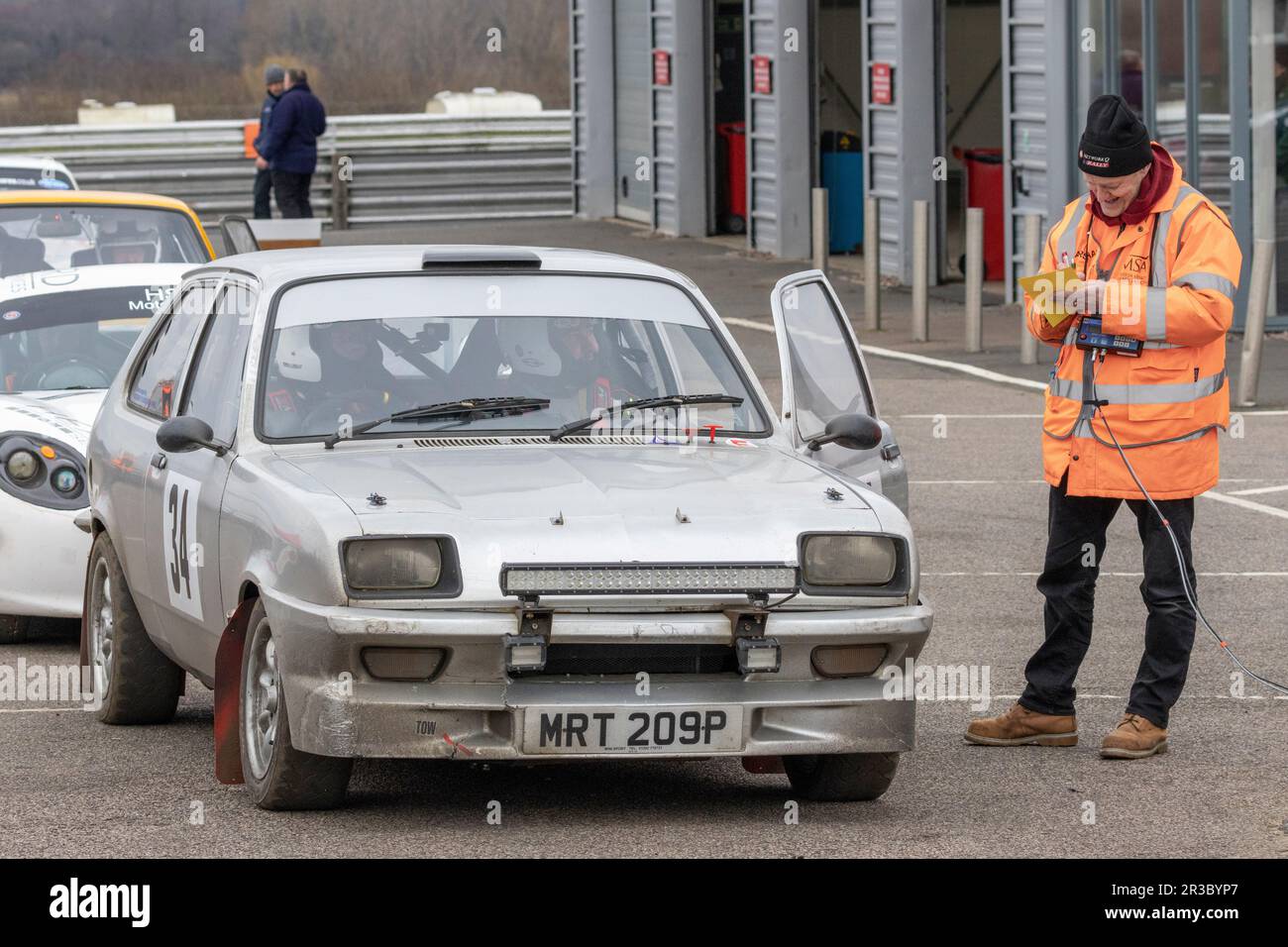 Mark Wade and Gordon Downie in their 1976 Vauxhall Chevette with the control point marshal during the 2023 Snetterton Stage Rally, Norfolk, UK. Stock Photo