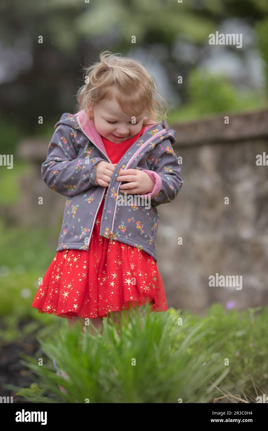 Cute little girl smiling outside Stock Photo - Alamy