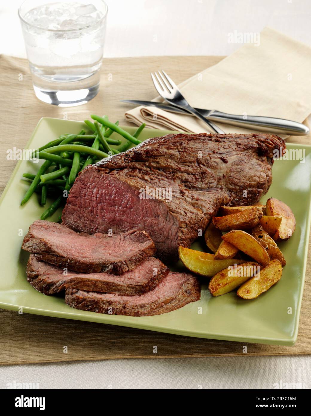 A beef Tri Tip roast with roasted potato wedges and green beans Stock