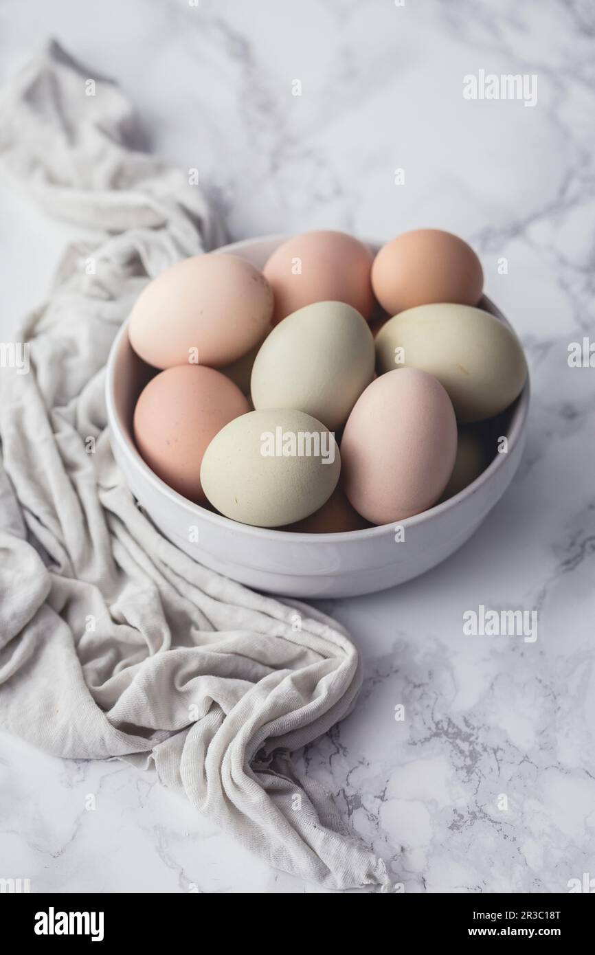 Fresh eggs in a bowl, on a marble surface Stock Photo