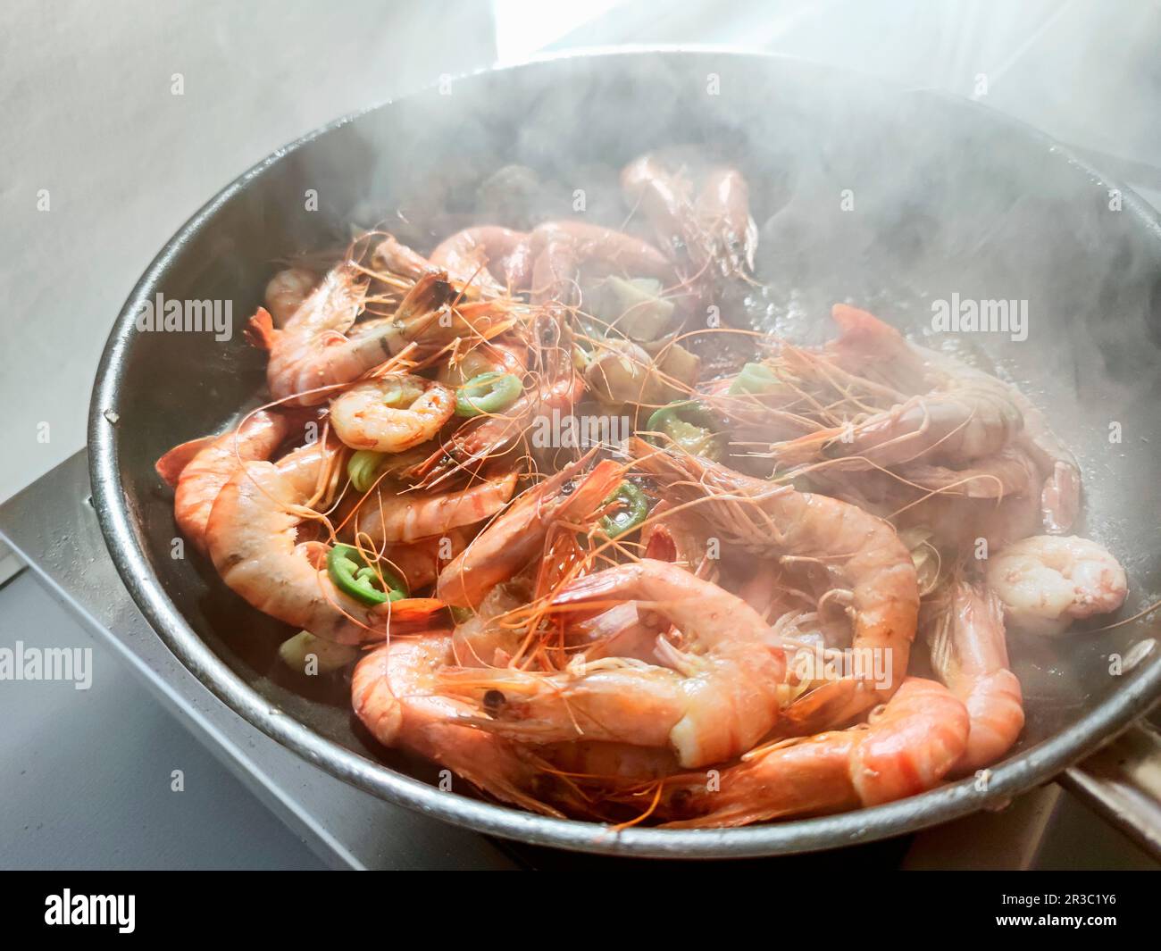 Frying shrimps in a frying pan Stock Photo - Alamy