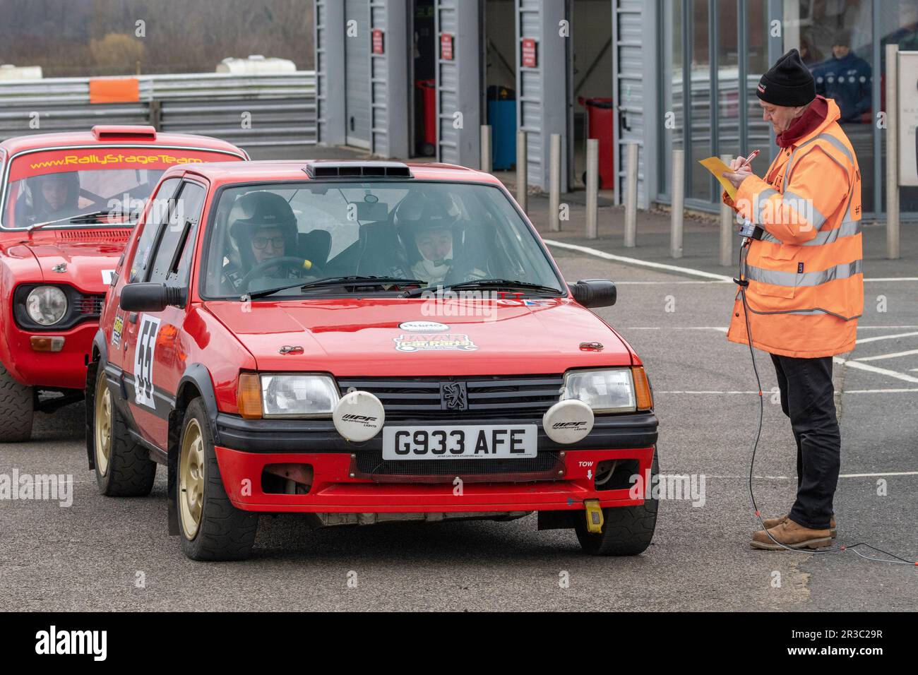 Paul Quinnell in the 1989 Peugeot 205 with the control point marshal ...