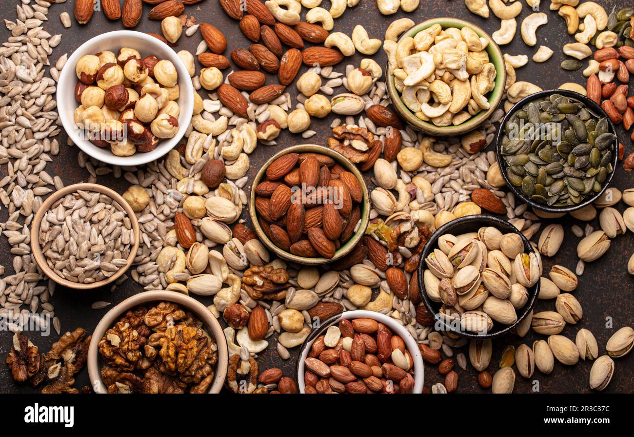 Assorted nuts and various seeds in bowls Stock Photo