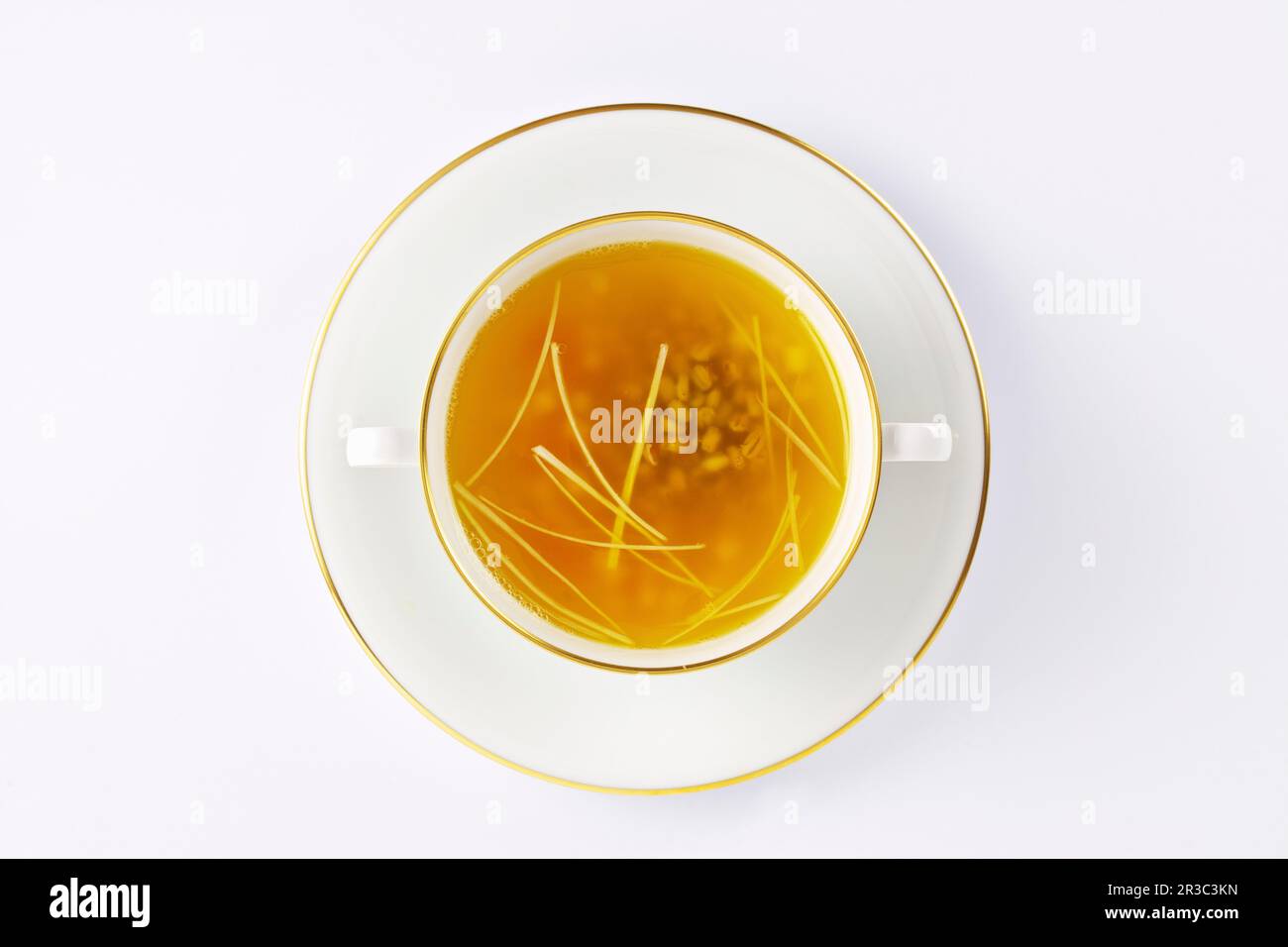 Chicken broth in a soup cup with a gold rim Stock Photo Alamy