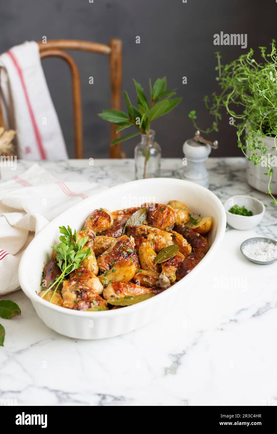 Chicken pieces roasted with potatoes and sausages Stock Photo Alamy