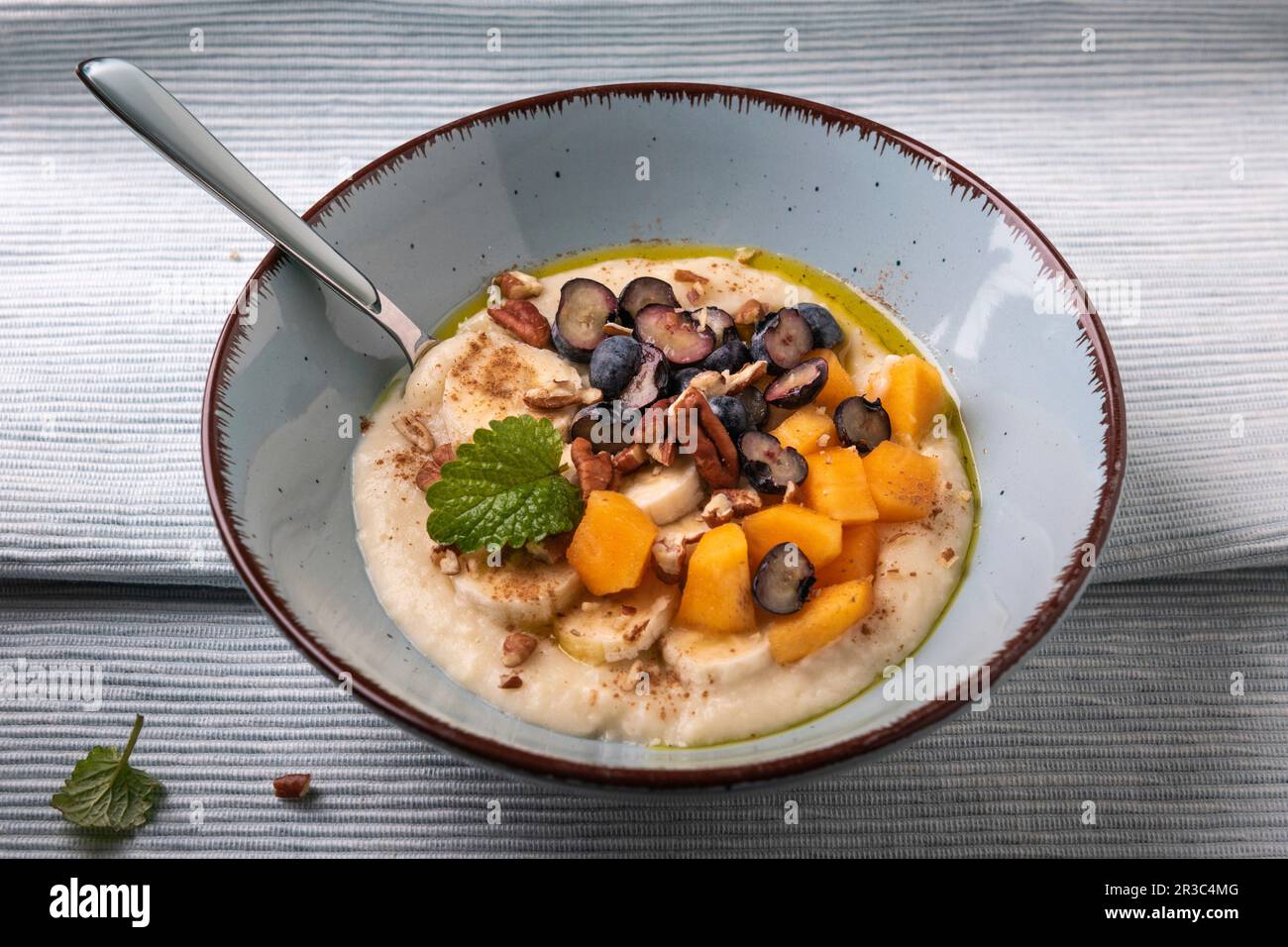 Millet porridge with persimmon, blueberries, banana, pecans and linseed