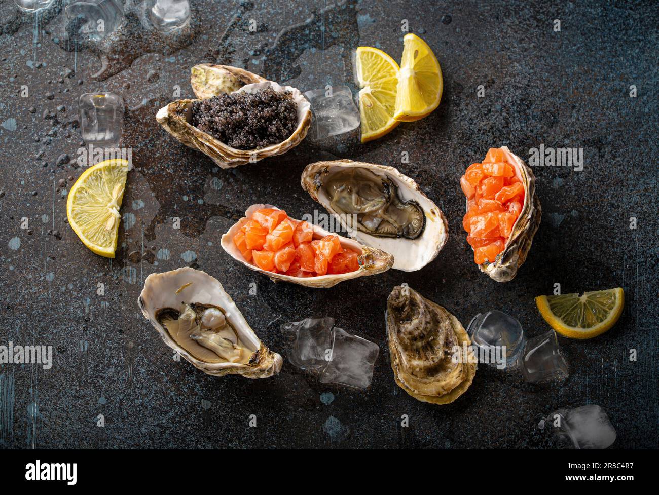 Seafood starters and appetizers: fresh open oysters, black caviar, and salmon tartare Stock Photo