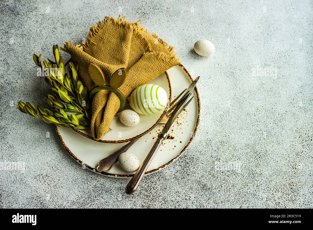 Easter festive table setting with tiny eggs and tableware on stone background Stock Photo