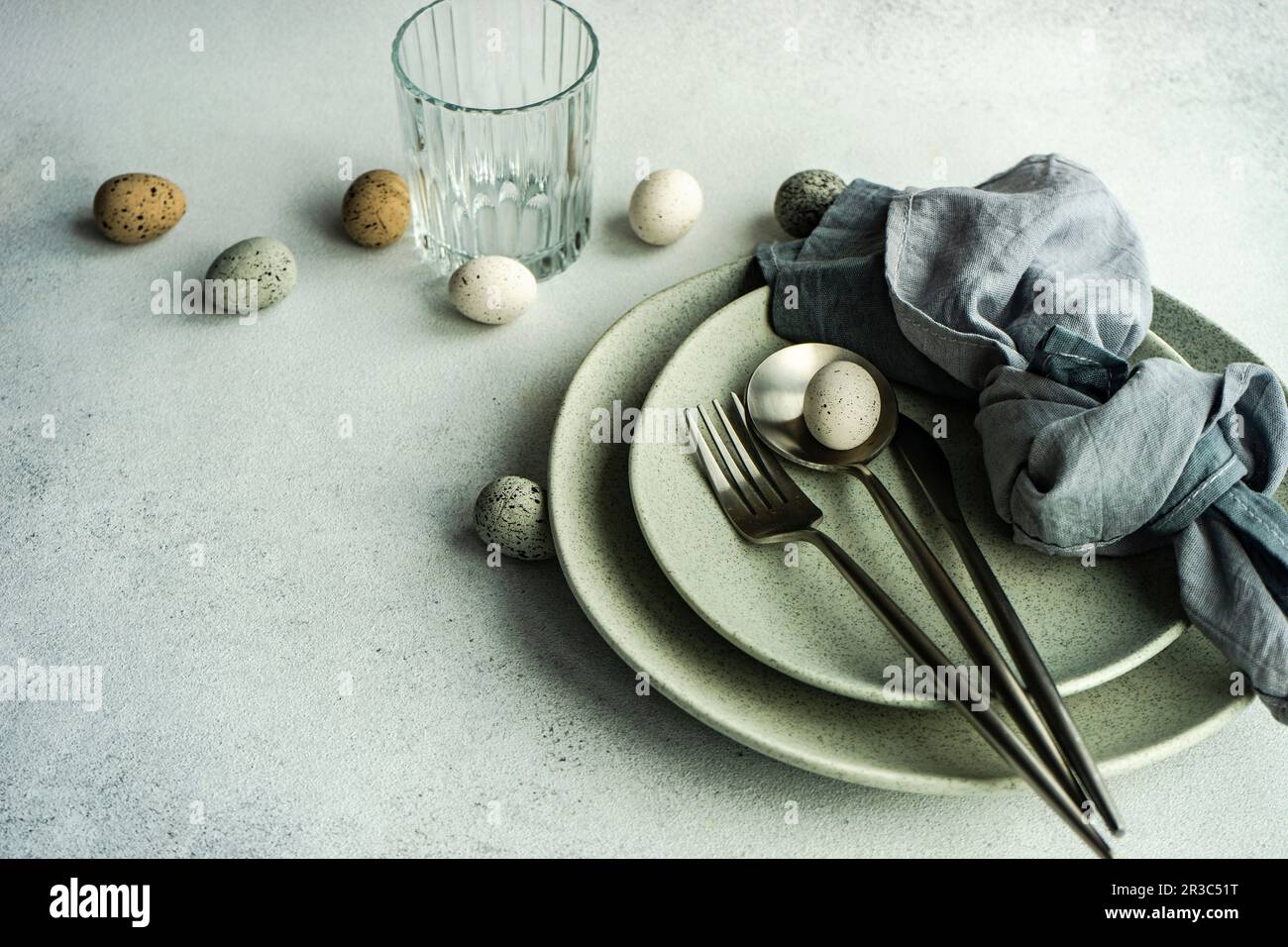 Place setting for Easter festive dinner with eggs on concrete background Stock Photo
