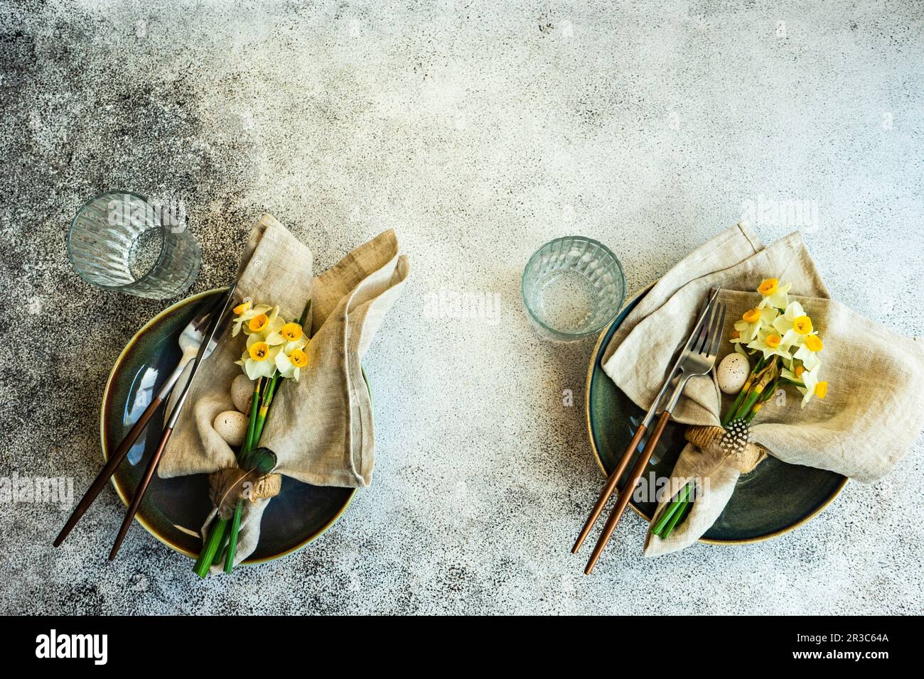 Minimalistic table setting for easter festive dinner decorated with daffodil flowers Stock Photo