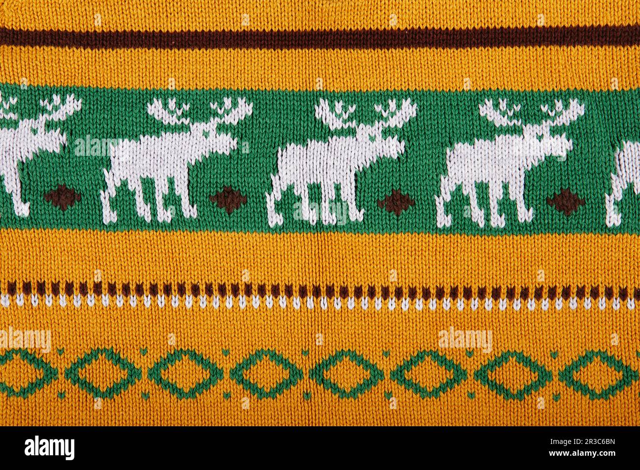 Christmas ornamental knitting with deers. knitted sweater background texture. Real knitted fabric te Stock Photo