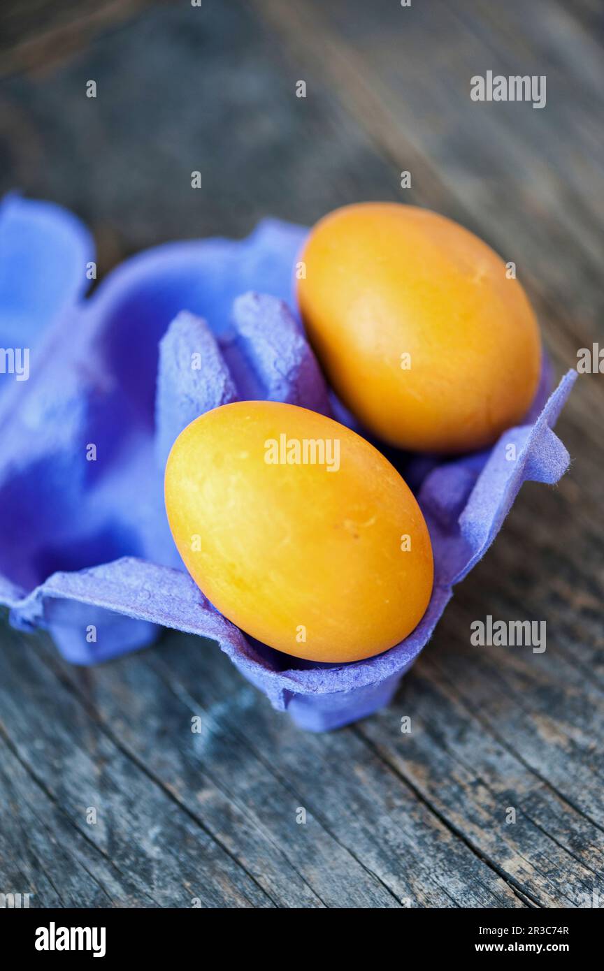 Yellow Easter eggs in a purple cardboard Stock Photo