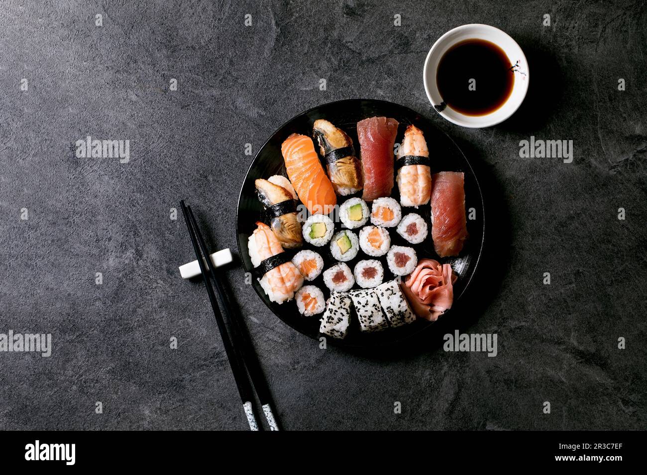 Sushi rolls set with fresh salmon, tuna, eel and prawns on rice. Flat lay, copy space Stock Photo