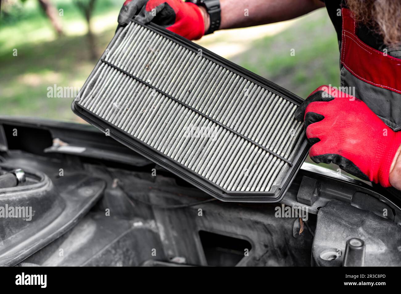 air filter of an internal combustion engine in the hands of a mechanic. Filter replacement and car repair. Stock Photo