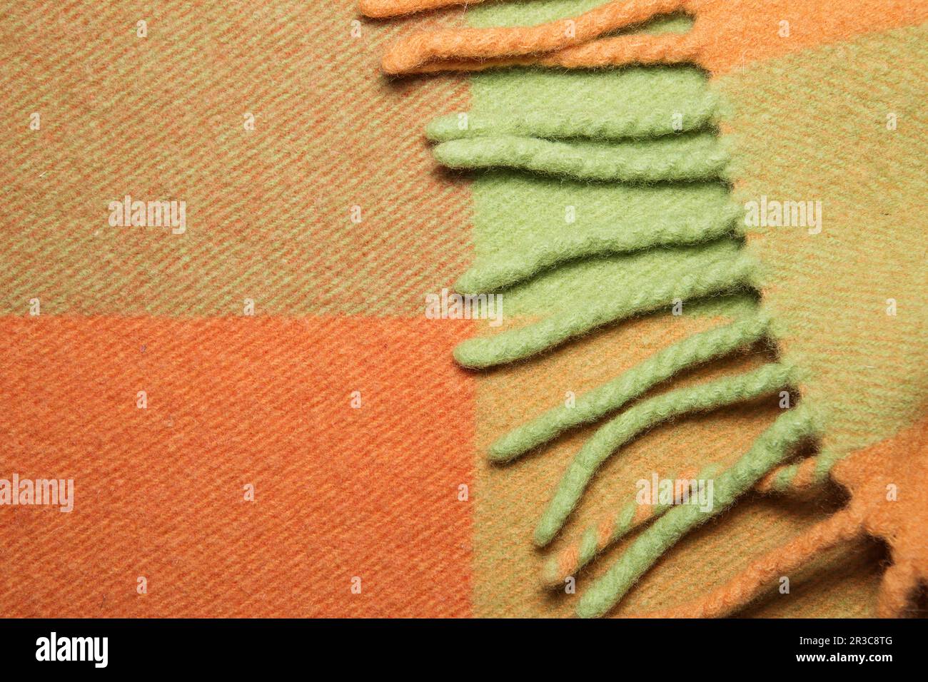 Soft and warm folded alpaca wool blanket with fringe. Green and orange