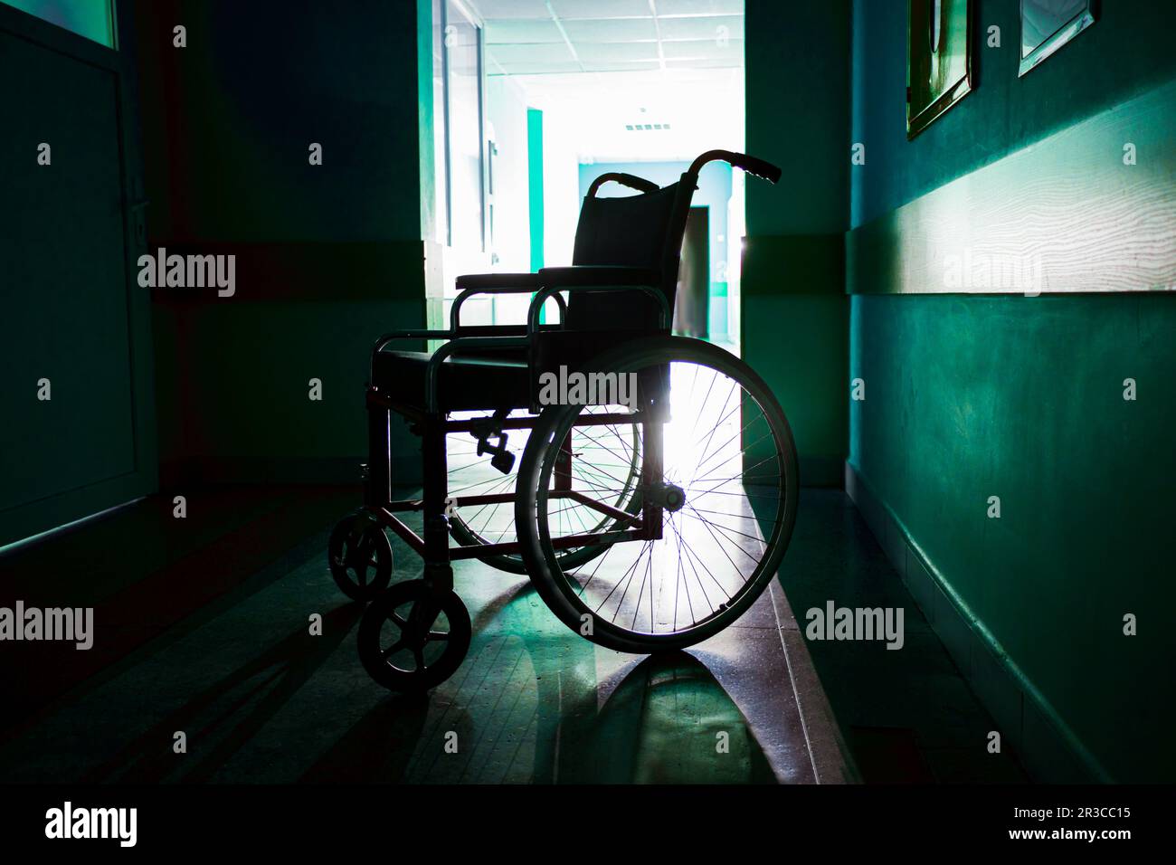 Silhouette of empty wheelchair parked in the hospital corridor Stock Photo