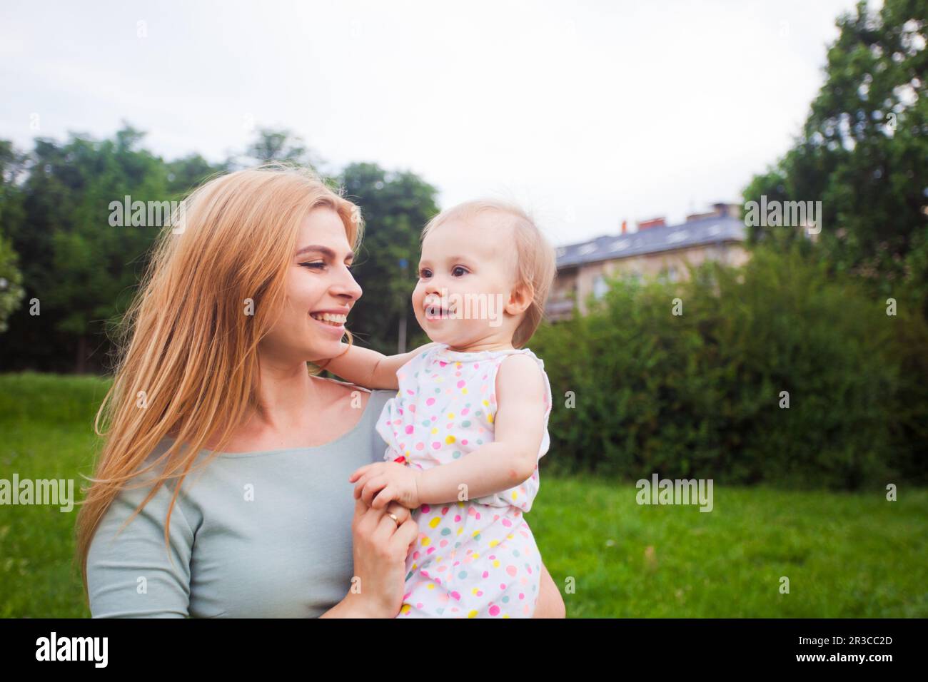 The mom and her baby have fun together outdoors Stock Photo