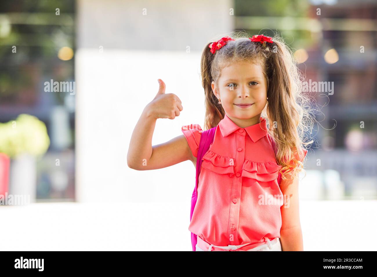 The schoolgirl back to school and showing thumb up Stock Photo - Alamy