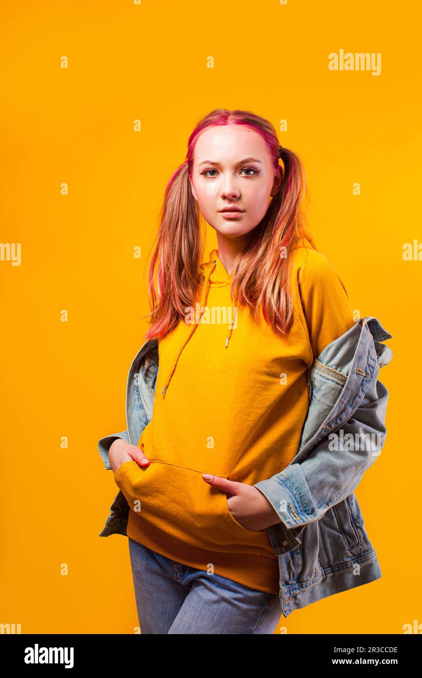 Attractive teenage girl holding her belly on yellow background Stock Photo