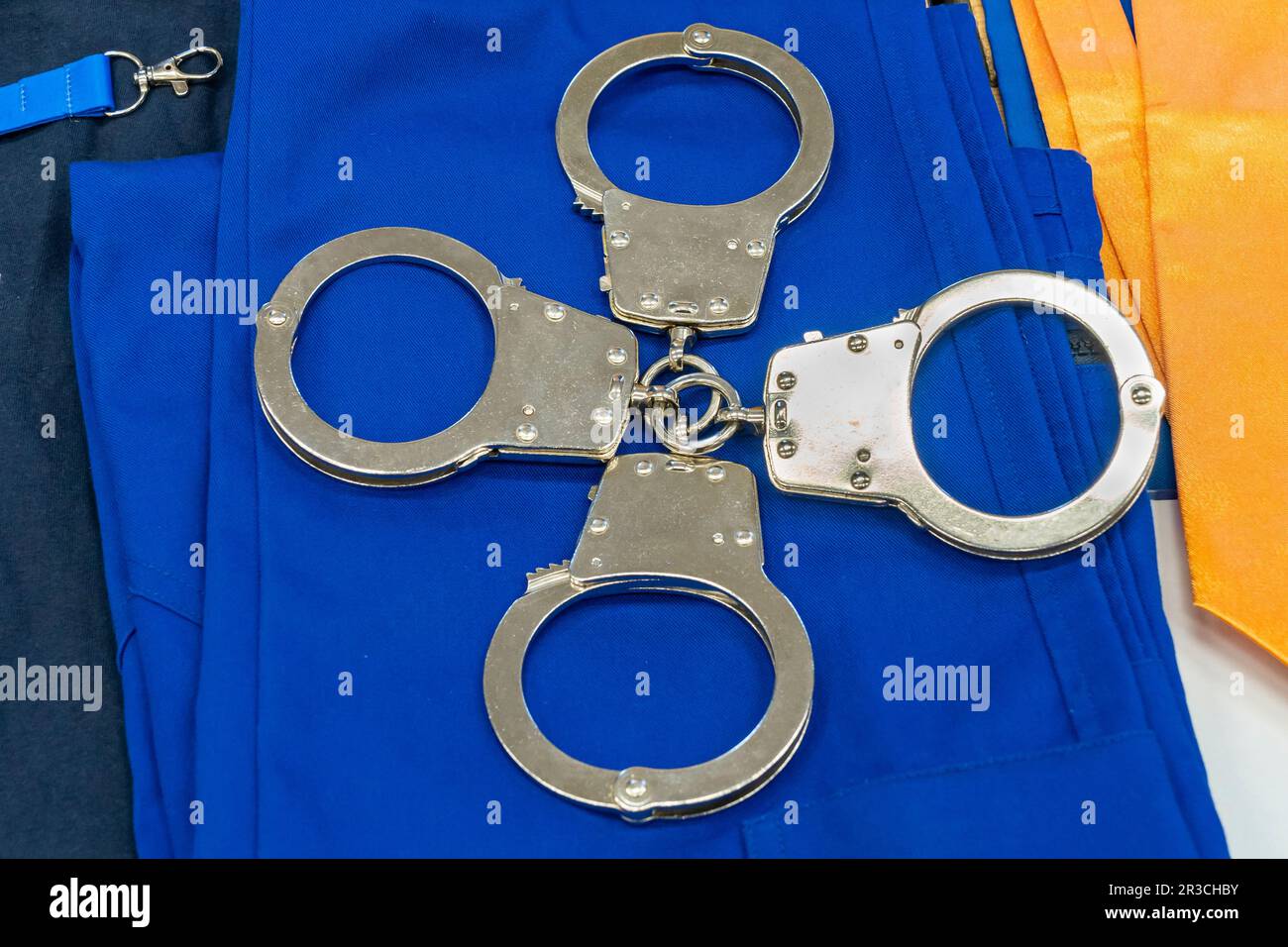 Police handcuffs on a blue background Stock Photo