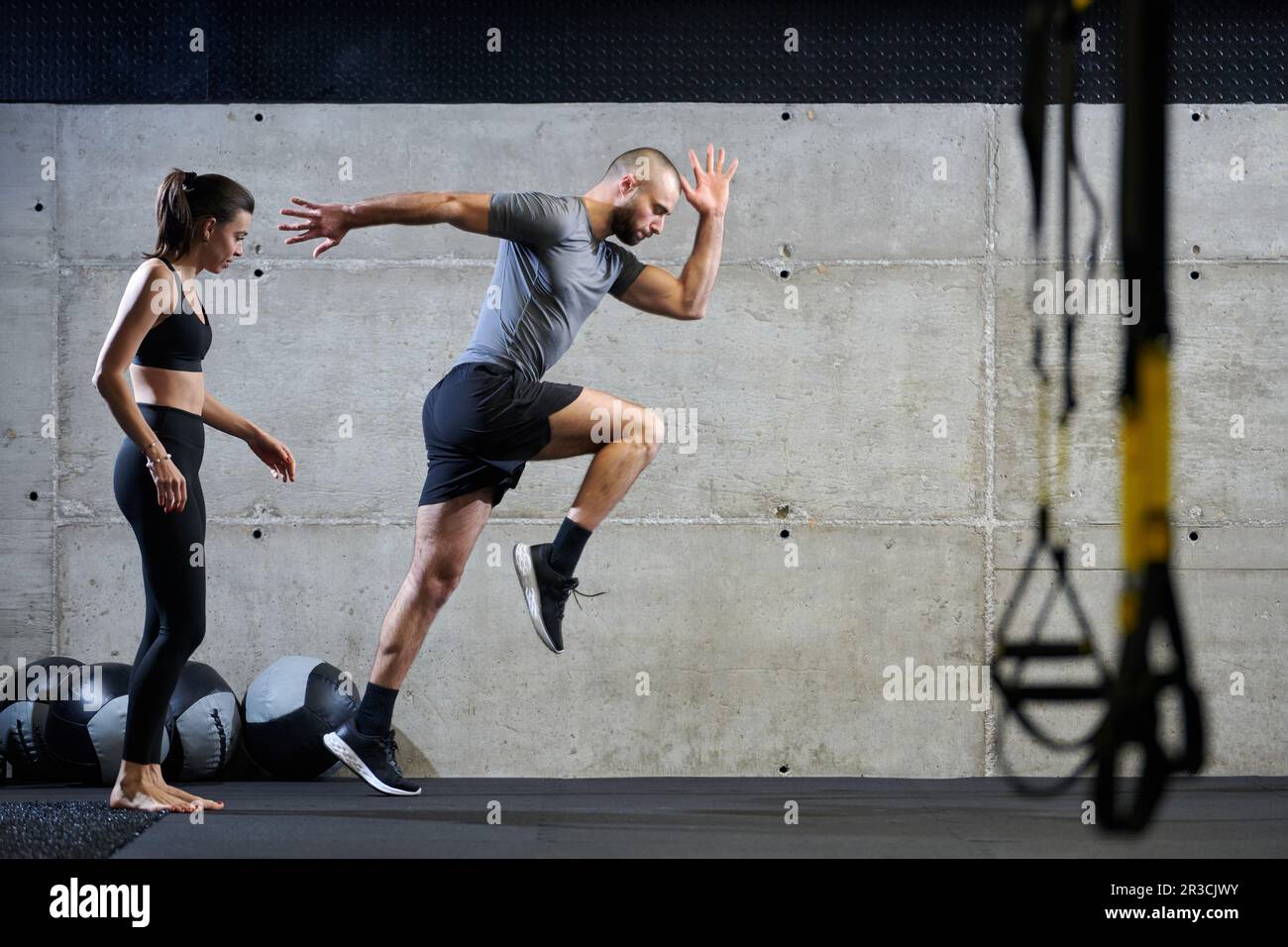 A fit couple in a modern gym, engaging in running exercises and