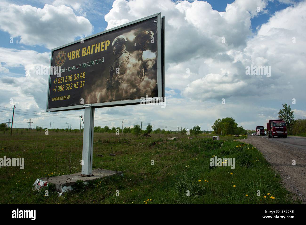A dump truck drives past a billboard on a highway near St. Petersburg in the Leningrad Region depicting Russian servicemen and an advertisement for a private military company, PMC Wagner, with the inscription 'Join the winning team'. On May 20, 2023, the founder of a private military company, Yevgeny Prigozhin, made a statement that the PMC Wagner group had completely taken the city of Bakhmut under its control. Stock Photo