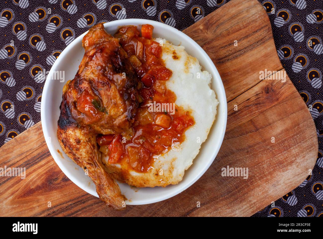 Traditional South African pap or maize meal with traditional sauce of tomato and onion on traditional textile Stock Photo