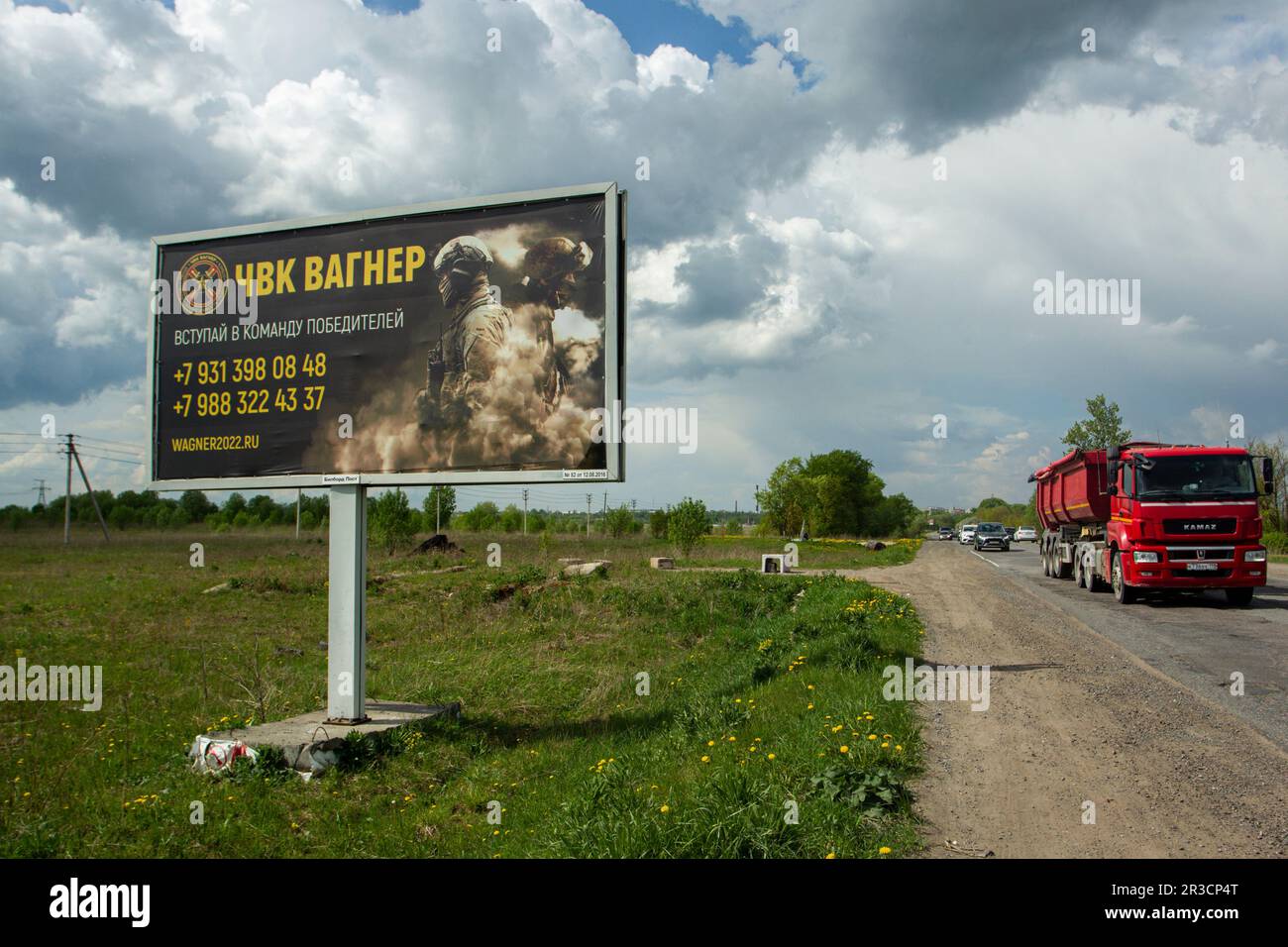 A dump truck drives past a billboard on a highway near St. Petersburg in the Leningrad Region depicting Russian servicemen and an advertisement for a private military company, PMC Wagner, with the inscription 'Join the winning team'. On May 20, 2023, the founder of a private military company, Yevgeny Prigozhin, made a statement that the PMC Wagner group had completely taken the city of Bakhmut under its control. Stock Photo