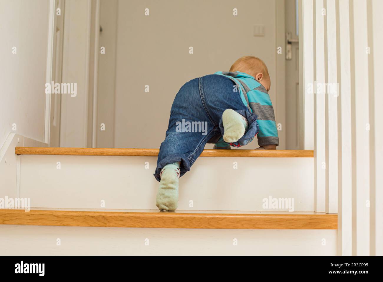 10 months adorable baby climbing up stairs at home. Little boy training