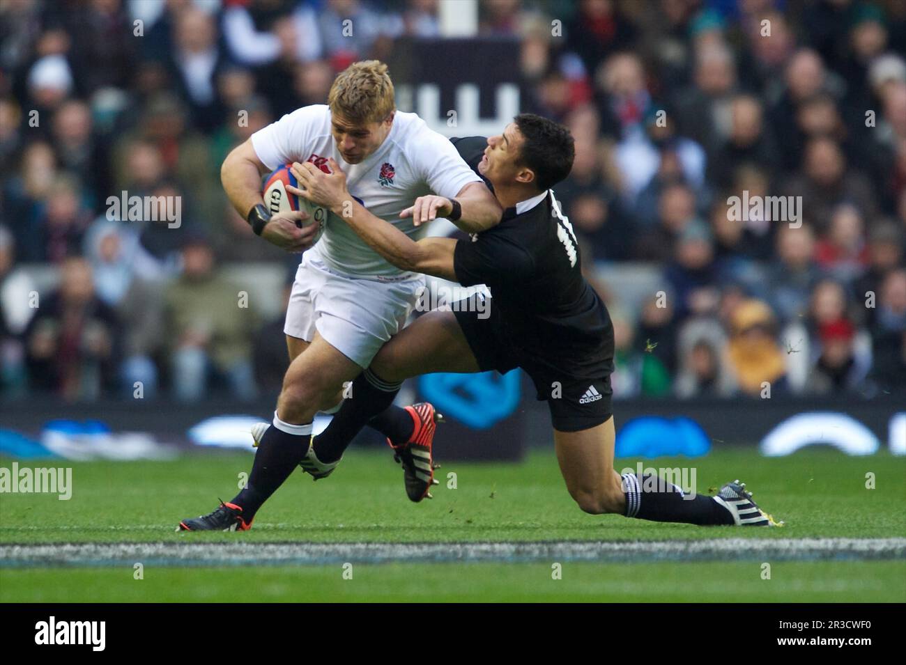 Tom Youngs of England is tackled by Dan Carter of New Zealand during the QBE Autumn International match between England and New Zealand at Twickenham Stock Photo