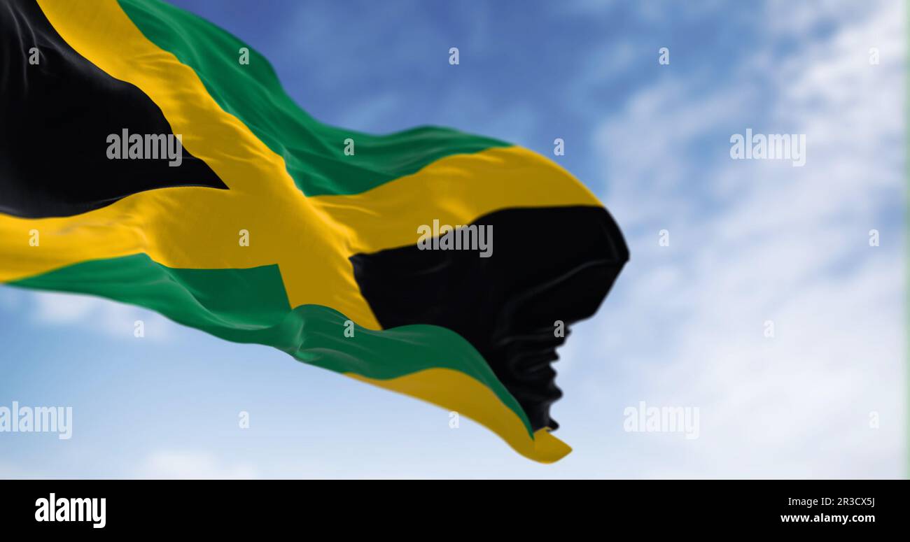 Jamaica national flag waving in the wind on a clear day. Gold saltire dividing it into four sections: two green and two black. 3d illustration render. Stock Photo