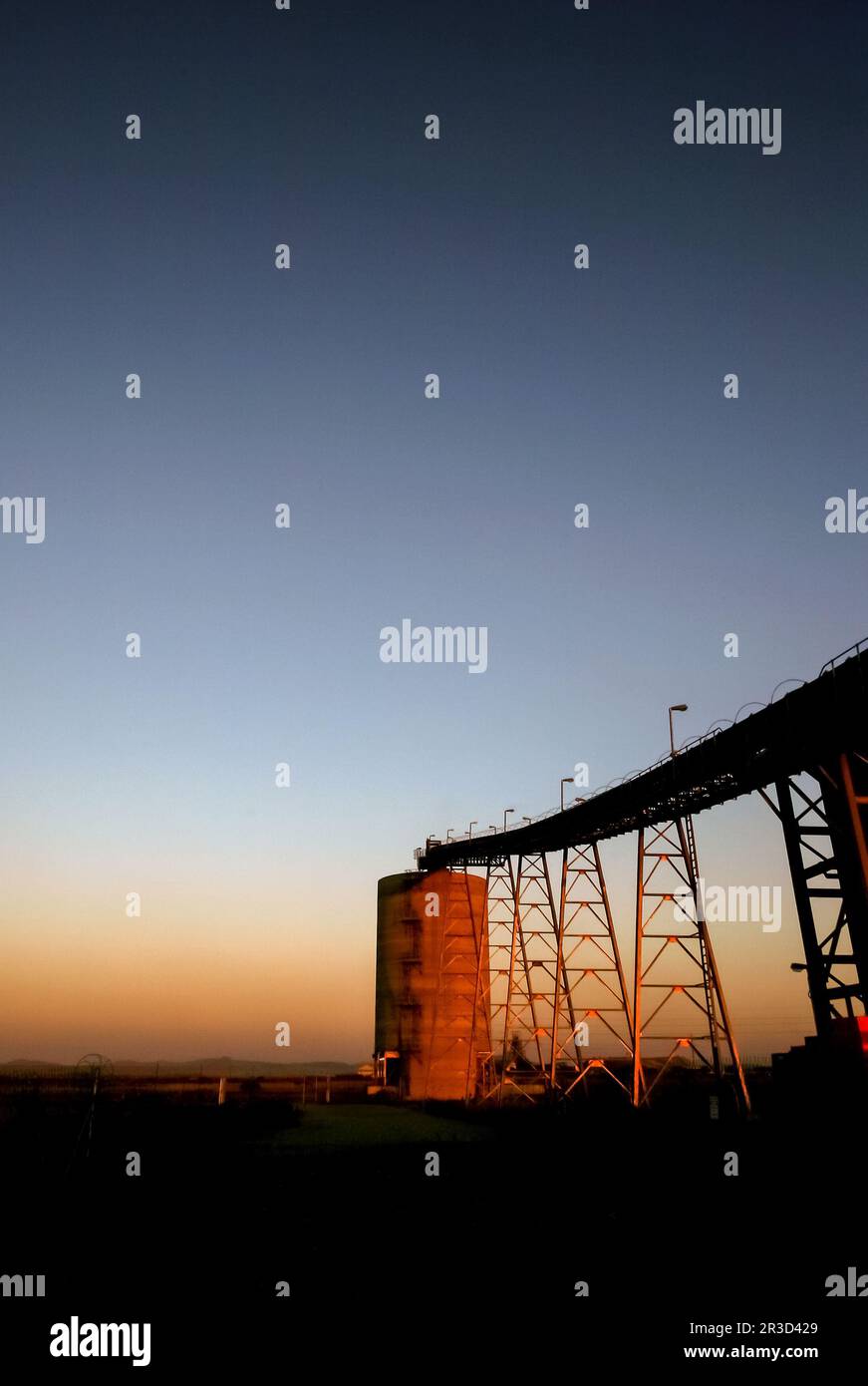 Silhouette of a mining silo and conveyor belts Stock Photo