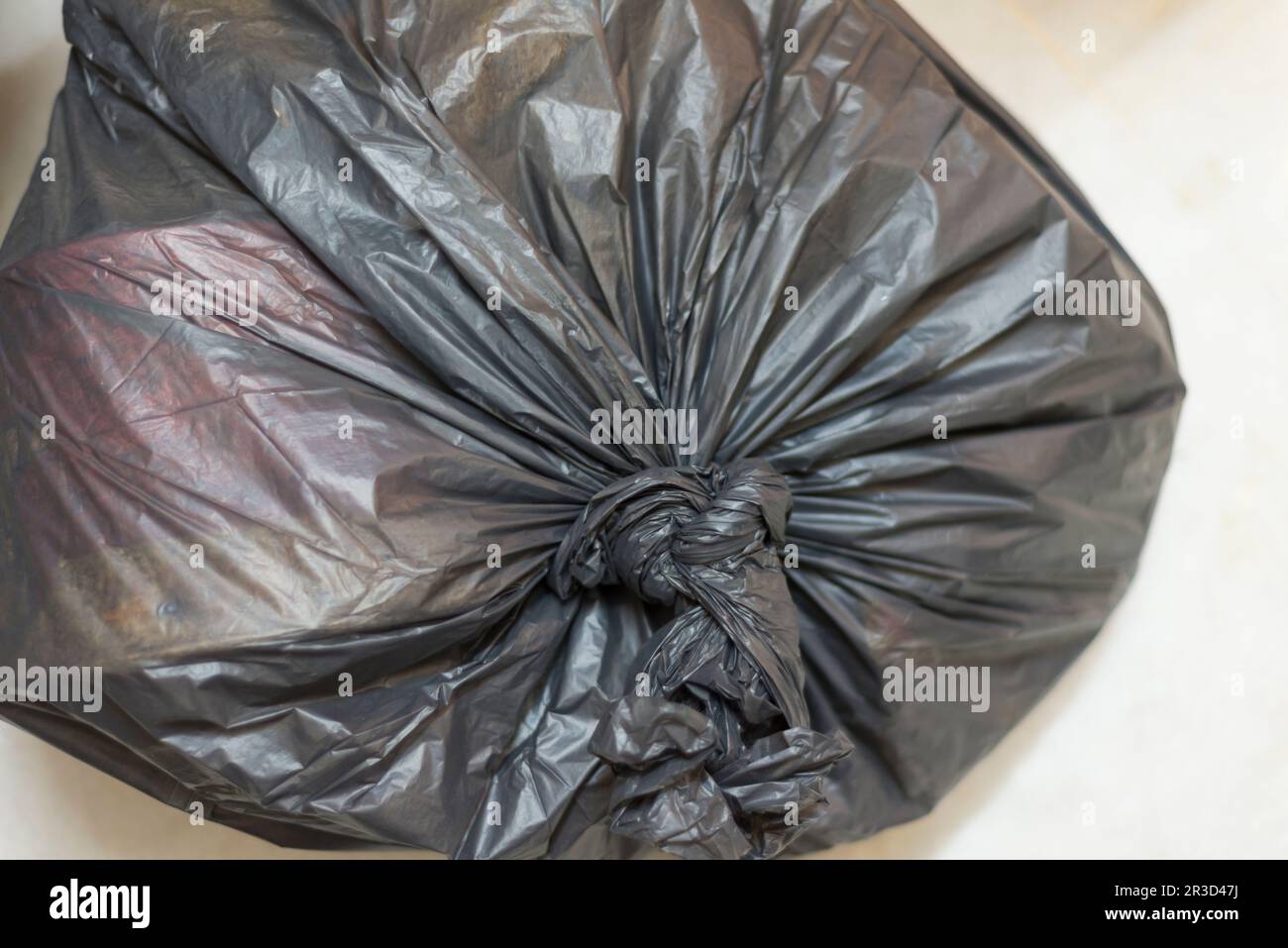 https://c8.alamy.com/comp/2R3D47J/a-knotted-garbage-trash-bag-filled-with-household-waste-2R3D47J.jpg