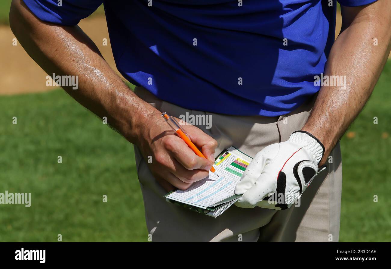 Golfer keeping score on scorecard Stock Photo