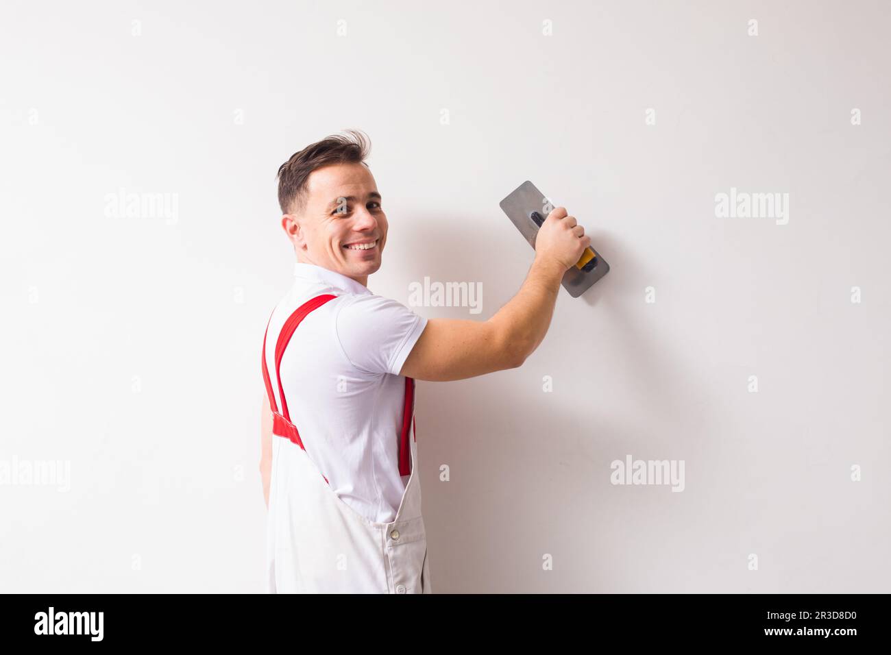 The plasterer is aligning wall using a special tool Stock Photo