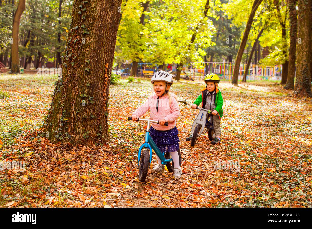 Cheerful preschool kids outdoors on balance bikes Stock Photo